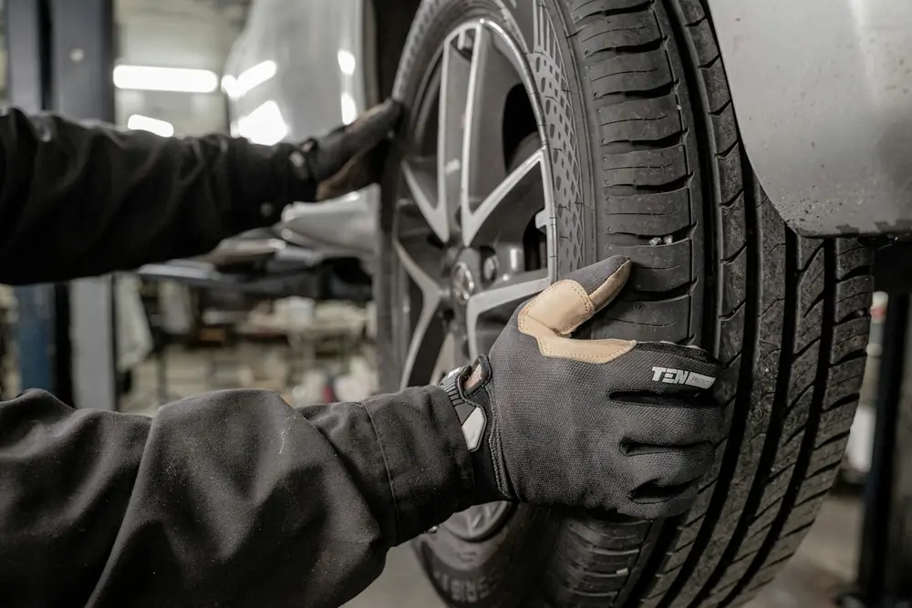 A technician fitting a wheel onto a vehicle