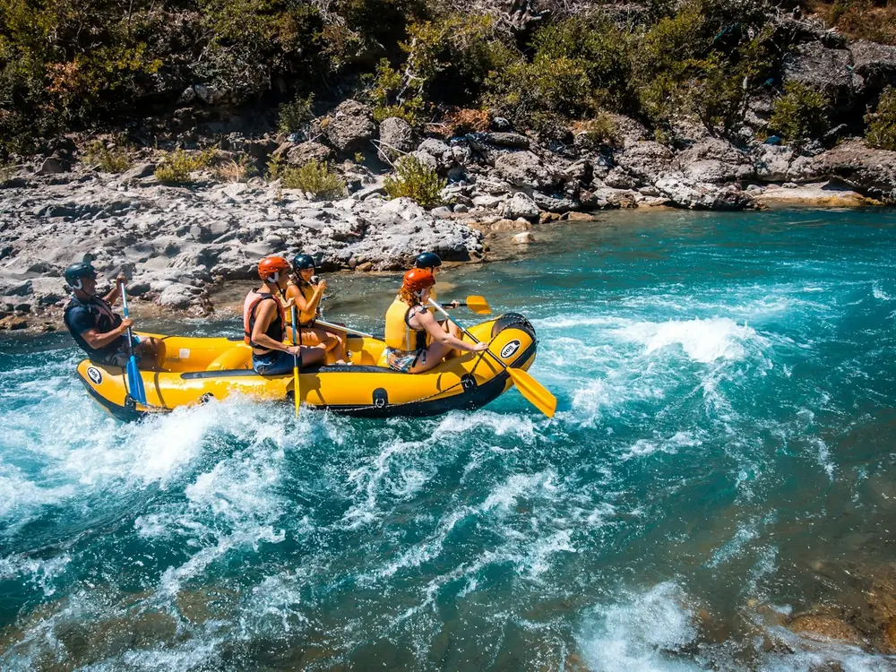 A raft of paddlers punching through whitewater